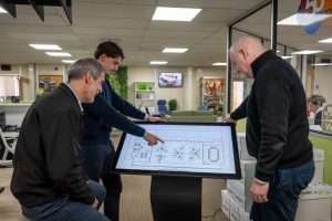 Team members consulting 3D designs to plan an office refurbishment